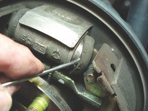 When inspecting a drum brake, always inspect the wheel cylinder for leakage by prying away the rubber end cap. Because they can’t be successfully honed, aluminum wheel cylinders should be replaced.